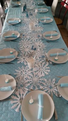 the table is set with blue and white plates, silverware, and napkins