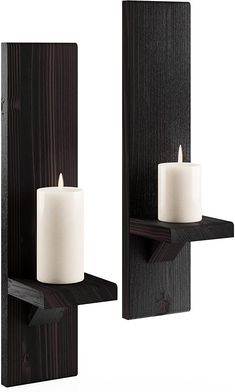 two candles are sitting on the wooden shelfs, one is white and the other is black