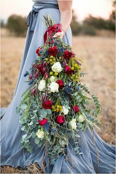 a woman in a blue dress holding a bouquet of flowers