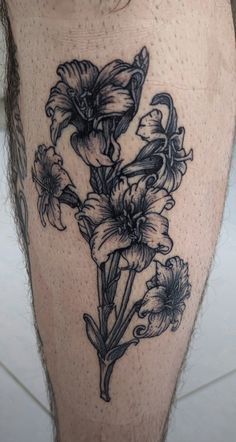 a close up of a person's leg with flowers on it