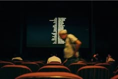 people are sitting in an auditorium watching something on the screen