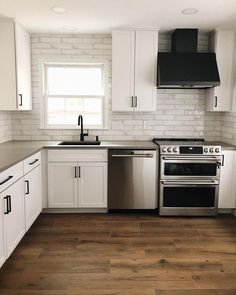 an empty kitchen with white cabinets and stainless steel stove top oven, dishwasher and microwave