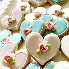 heart shaped cookies decorated with flowers and hearts on a platter for valentine's day