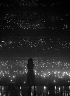 a person standing in front of a stage with lots of lights on the wall behind them