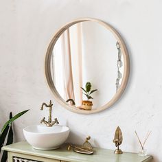 a bathroom with a sink and mirror on the wall next to a potted plant