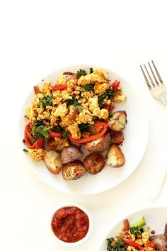 a white plate topped with meat and veggies next to a bowl of sauce