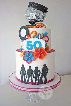 there is a white cake with the number 50 on top and people around it, all decorated in different colors