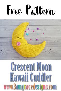 a crocheted crescent moon sitting on top of a white wooden floor with stars