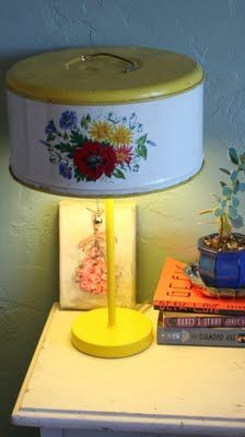 a lamp that is sitting on top of a table next to some books and flowers