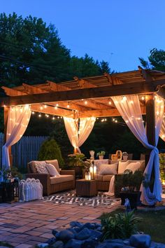 an outdoor living area with lights and curtains