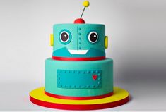 a blue and yellow cake with a robot on top