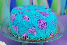 a blue and purple cake sitting on top of a glass plate