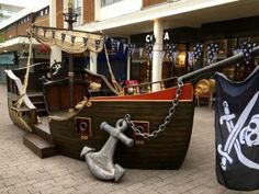 an old pirate ship is chained to a pole in the middle of a shopping mall