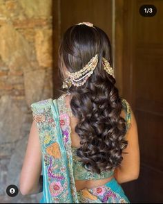 the back of a woman's head, with long hair and jewelry on it