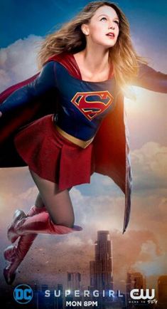 a woman flying through the air while wearing a superman suit and cape in front of a cityscape