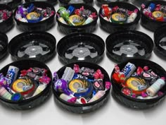 several black containers filled with candy and candies