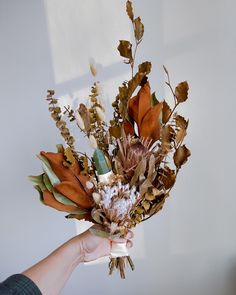 a person holding a bouquet of flowers in their hand