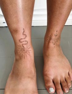 two people with tattoos on their feet and one has a snake tattooed on the foot