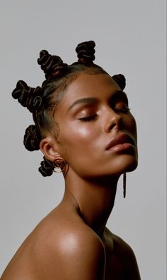 a woman with her eyes closed and hair in buns on top of her head