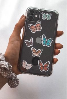 a person holding an iphone case with butterflies on it