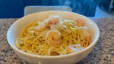 a white bowl filled with pasta and shrimp