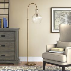 a living room with a chair, lamp and dresser