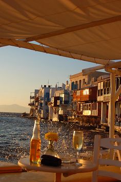 an outdoor dining area overlooking the water and buildings