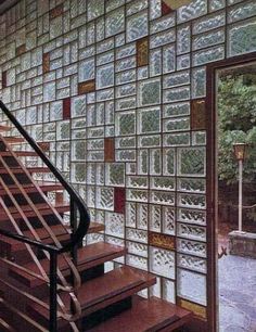 a stair case with glass blocks on the wall and wooden steps leading up to it