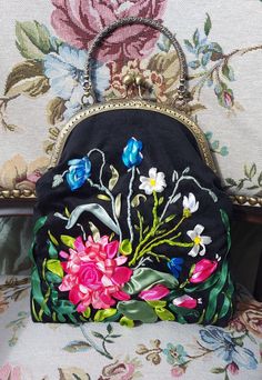 a purse with flowers on it sitting on a chair