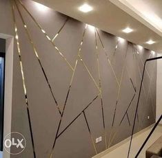 a room with some lights on the ceiling and an artistic wall decoration in gold foil