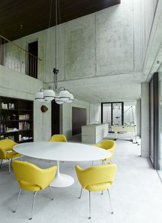 a white table and yellow chairs in a room