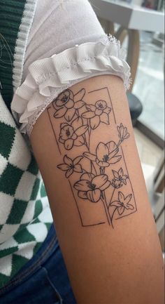 a woman's arm with flowers on it and the letter f in black ink