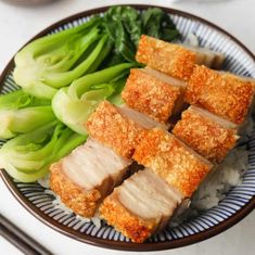 a plate filled with meat and vegetables next to chopsticks