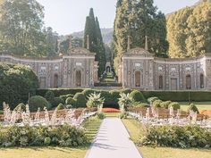 an outdoor wedding setup with chairs and flowers in the foreground, surrounded by greenery