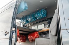 the inside of a van with its doors open and bags on the back door area