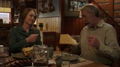 a man and woman sitting at a table with food