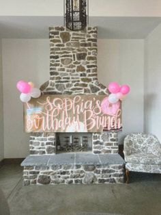 a decorated fireplace with pink balloons and a happy birthday sign