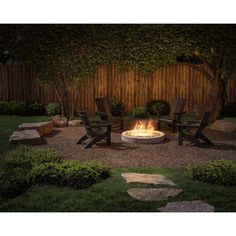 a fire pit surrounded by lawn chairs in a back yard with grass and rocks around it