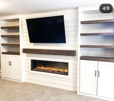 an entertainment center with built - in fireplaces and shelving around the tv screen