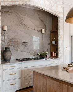 a kitchen with marble counter tops and white cabinets