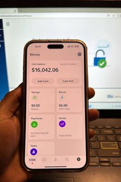 someone is holding up their cell phone to pay on the computer screen and it's open