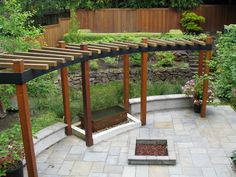 an outdoor area with several wooden structures and plants growing on the walls, along with stone flooring