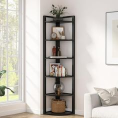 a living room with a white couch and a black book shelf in the corner next to a window