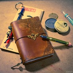 a notebook, pen and other personal items are on the table next to each other