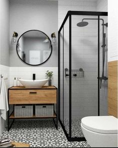 a bathroom with a sink, mirror and shower stall in black and white tiles on the floor