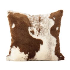 a brown and white cowhide pillow on a white background