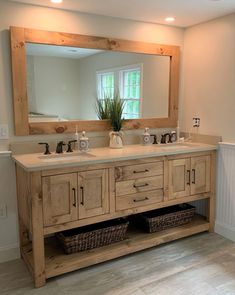 a bathroom vanity with two sinks and a large mirror above it, along with wicker baskets under the sink