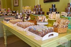 the table is covered with lots of different types of candies and candy bars for sale