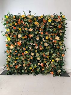 an artificial flower wall is shown in the middle of a room with tile flooring