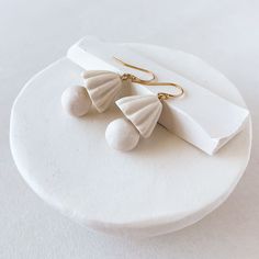 Our Shade Earrings are a fusion of interior design and fashion inspiration. These earrings are a testament to our fascination with the wavy textures found in lampshades. They feature funky sculpted porcelain with an intriguing wavy texture, suspended elegantly from 14-karat gold-fill french wires. Hand sculpted porcelain and always crafted with care. Elegant Clay Drop Earrings, Neutral Dresses, Gold Piece, French Wire, Gold Shimmer, Interior Design Styles, Lampshades, Cleaning Clothes, Fascinator